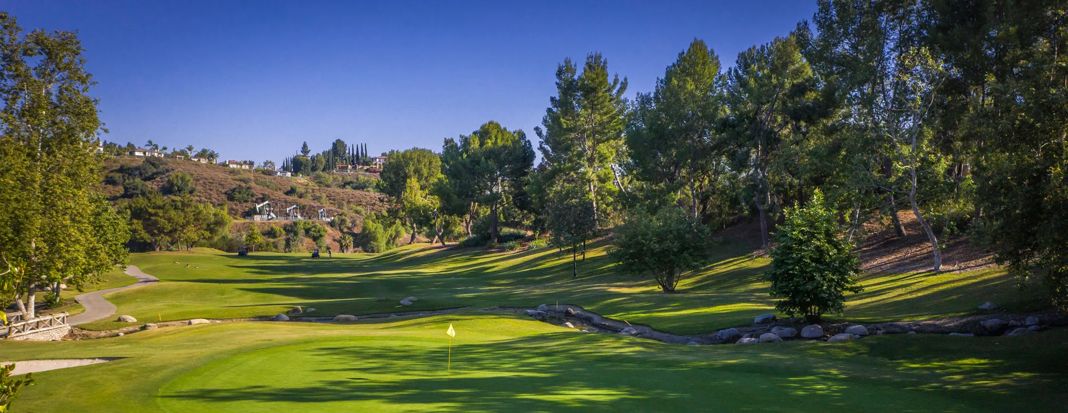 Wide view down a fairway toward the Fullerton hills