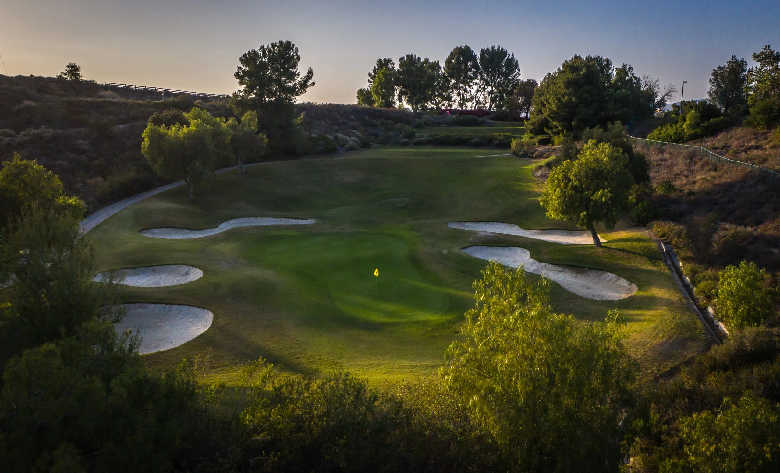 Aerial view of a bunkered green below the tee